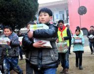 2016年1月8日下午,在駐馬店市汝南縣三門閘街道大新莊小學校院內(nèi)，駐馬店市陽光助學協(xié)會負責人及志愿者、大新莊學校師生、學生家長歡聚一堂，舉行了“陽光助學愛心圖書室”捐贈儀式。圖為學生和志愿者一起搬運新書