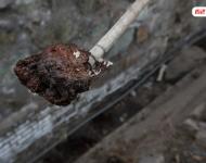 在遷安市中化煤化工有限責任公司的圍墻外是污水排放溝，溝里的泥成為紅褐色。