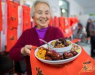 1月4日，內(nèi)蒙古呼和浩特市玉泉區(qū)清泉街社區(qū)一位老人在展示臘八粥食材。當(dāng)日，呼和浩特市玉泉區(qū)清泉街社區(qū)舉辦“溫暖臘八粥 濃濃鄰里情”活動，喜迎即將到來的“臘八節(jié)”。新華社發(fā) 丁根厚 攝