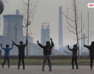 圖為耗資13億建成的邯鄲武安市體育館外，本地的不少中年婦女，每天會在固定時間來到這里：她們背對體育館，面向文安鋼鐵廠，跳起了廣場舞。邯鄲武安市區有十幾個鋼鐵廠、電廠、焦化廠包圍，不管刮什么風，城區污染都很嚴重。視覺中國
